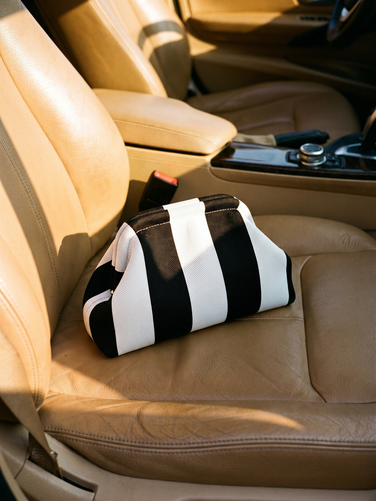 Monochrome Wide Stripe Cloud Pouch — sits on a car passenger seat, taking up well under half the width of the seat cushion